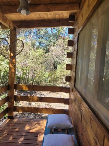 a wooden porch with a bench and a window at RUNA YAKU KAUNAZ in Salta