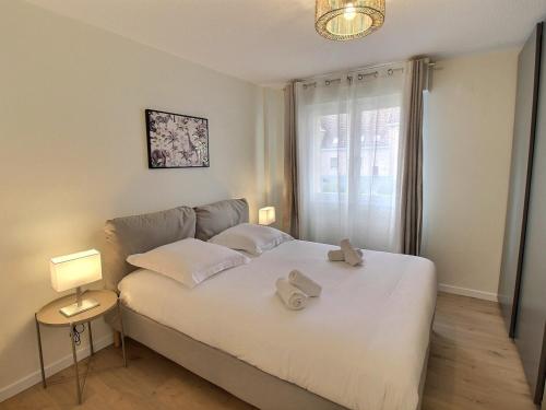 une chambre avec un lit blanc avec deux serviettes dessus dans l'établissement Appartement rénové près du centre de Colmar avec balcon, 2 chambres et Wi-Fi inclus - FR-1-722-7, à Colmar
