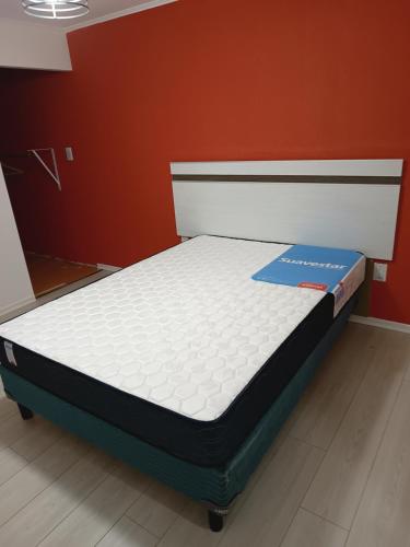 uma cama com um sinal azul num quarto em Casa Catalina zona sur em Comodoro Rivadavia