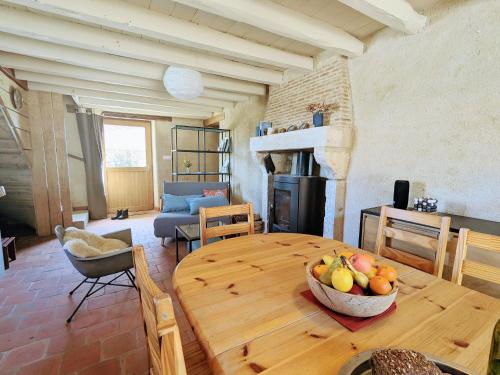 Cette chambre dispose d'une table en bois avec un bol de fruits. dans l'établissement Gîte de charme à la ferme avec jardin clos et activités familiales - FR-1-591-582, à Thenay