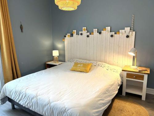 - une chambre dotée d'un lit blanc avec un oreiller jaune dans l'établissement Charmant 2 pièces rénové, terrasse, parking, proche commerces et plage - Saint-Gilles-Croix-de-Vie - FR-1-224-810, à Saint-Gilles-Croix-de-Vie