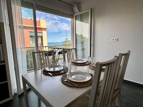 une table blanche avec des chaises, une table et une fenêtre dans l'établissement Argelès-sur-Mer : T2 Climatisé à 50m de la Plage, Balcon, TV, Lave-linge - FR-1-225-810, à Argelès-sur-Mer