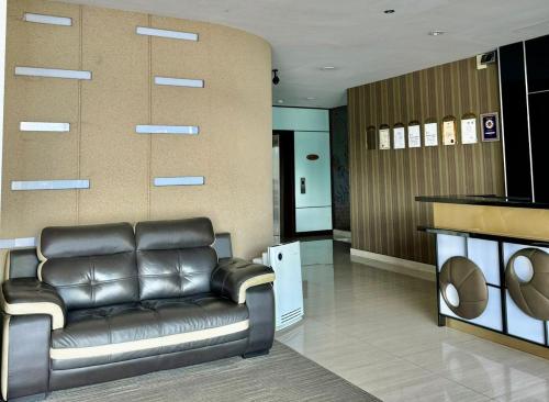 a lobby with a leather couch in a room at Chariton Hotel Nusa Bestari in Johor Bahru