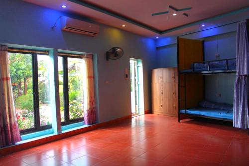 un soggiorno con illuminazione blu e una grande finestra di Pu Home Đỗ Quyên (Homestay Đỗ Quyên) a Bản Hon