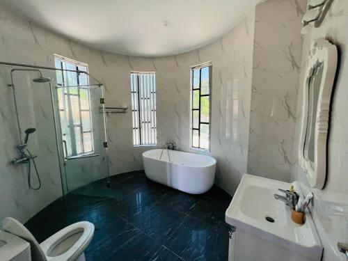 ein Badezimmer mit einer Badewanne, einem WC und einem Waschbecken in der Unterkunft New Luxury villa - Venuestay in Hà My Tây (2)