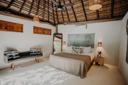 a bedroom with a bed and a chair in it at Sacred Hideaways in Tulum