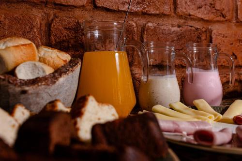 a plate of food with bread and orange juice at Pouso Du Ferreiro in Tiradentes