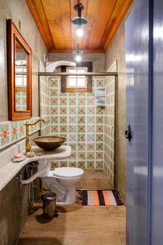 a bathroom with a sink and a toilet and a shower at Pouso Du Ferreiro in Tiradentes