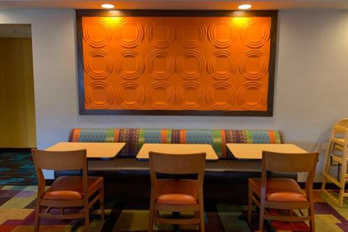 a restaurant with tables and chairs and a large screen at Fairfield Inn Concord in Concord