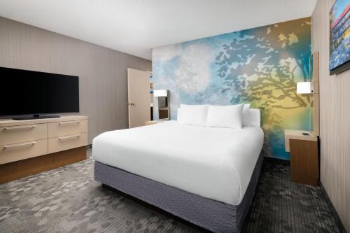 um quarto com uma cama grande e uma televisão de ecrã plano em Courtyard by Marriott Concord em Concord