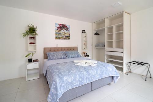 a white bedroom with a bed and a closet at Hospedaria Conceitual in Florianópolis