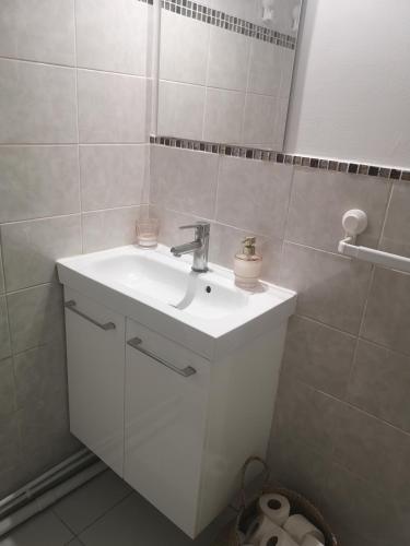 une salle de bain avec un lavabo blanc et un miroir dans l'établissement Appartement cosy à 10mn de l'aéroport d'Orly et proche de Paris, à Choisy-le-Roi