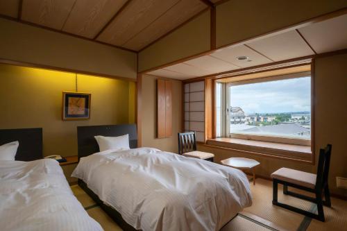 1 dormitorio con cama blanca y ventana en Kaike Tsuruya, en Yonago