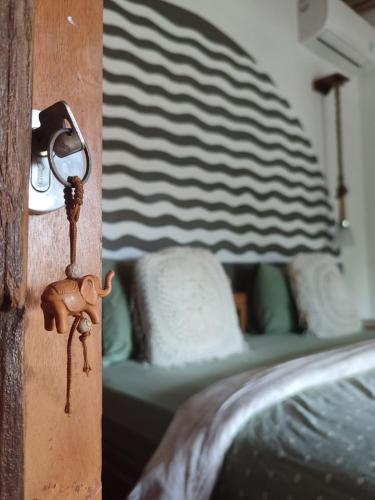 a key to a bedroom with a bed at Little Elephant Cottage in Gili Trawangan