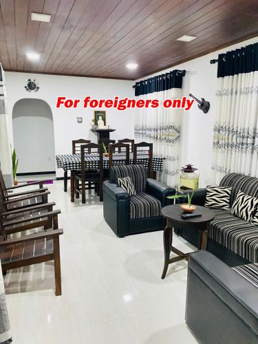 a for foreigners only store with couches and tables at JUNGLE VILLA in Galle