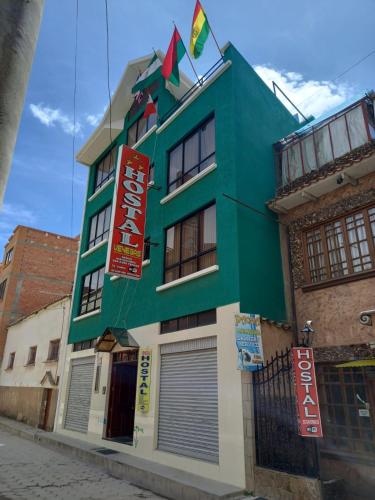 a green building with signs on the side of it at Hostal Venegas in Copacabana
