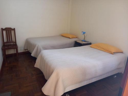 two twin beds in a room with a table at Hostal Venegas in Copacabana