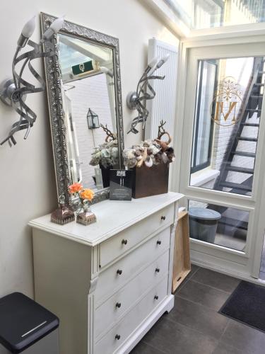 a dresser with a mirror on top of it at Hotel Montfoort in Montfoort