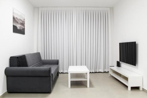 sala de estar con sofá, TV y mesa en Suite Apartment #17 By Hashdera Eilat, en Eilat