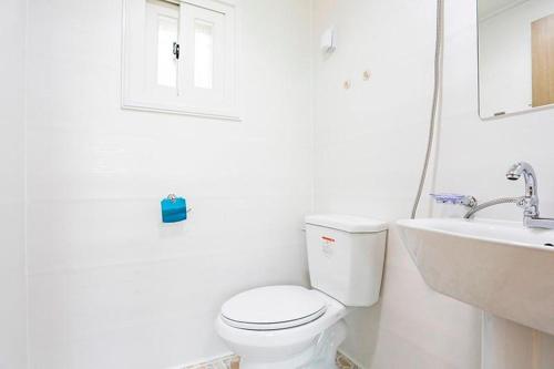 La salle de bains blanche est pourvue de toilettes et d'un lavabo. dans l'établissement Garden Pension, à Damyang