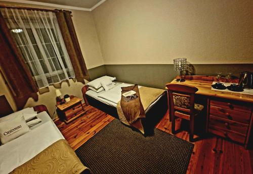a room with two beds and a desk and a desk at Starówka Boutique Hostel Cieszyn Centrum in Cieszyn