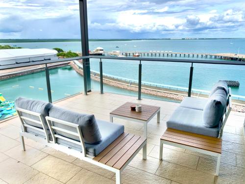 a balcony with two chairs and a table and the ocean at Serenity Blue Waters - 3 bedrooms on 8th floor at Darwin Waterfront in Darwin