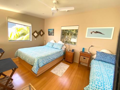 a bedroom with two beds and a window at Bliss on the Beach - Whangapoua in Whangapoua