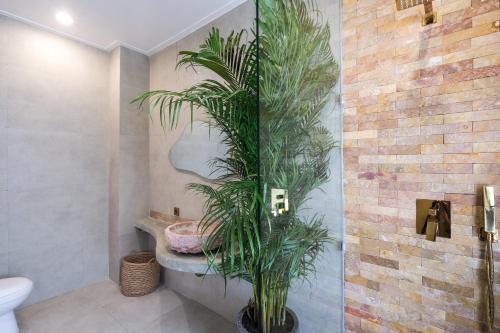baño con aseo y planta en la esquina en Tepui Villa Canggu, en Canggu