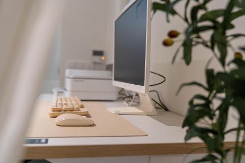 a computer monitor and a keyboard and mouse on a desk at The Hyoo Sik ANNK Hong Dae Branch in Seoul