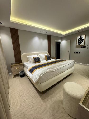 - une grande chambre avec un grand lit et un tabouret dans l'établissement شقة هادية ومميزة, à Riyad