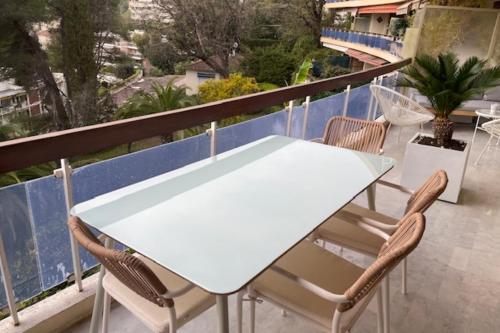 une table blanche et des chaises sur un balcon dans l'établissement Apartment with terrace in Le Cannet Colline, au Cannet