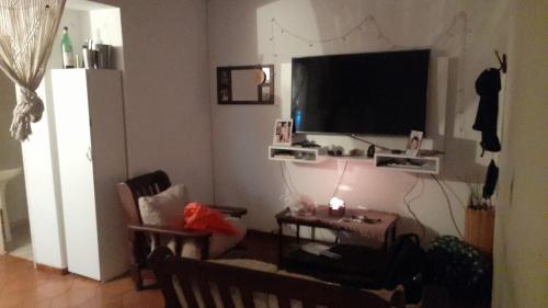uma sala de estar com uma televisão de ecrã plano e uma mesa em Departamento 2 H / Con balcón aterrazado em Morón