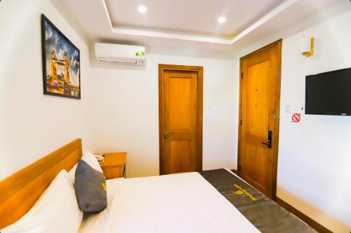 a bedroom with a bed and a flat screen tv at Sea Star Hotel Quy Nhon in Quy Nhon