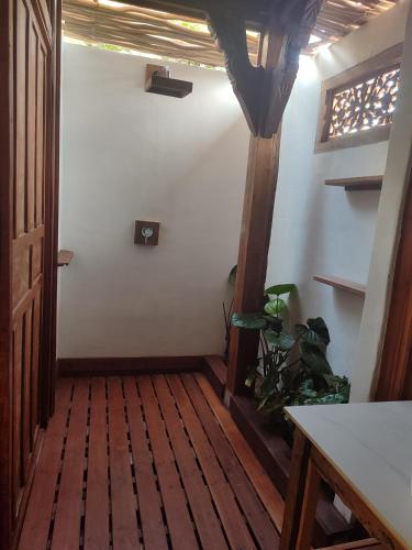 a hallway with a wooden floor and a door at Little Elephant Cottage in Gili Trawangan