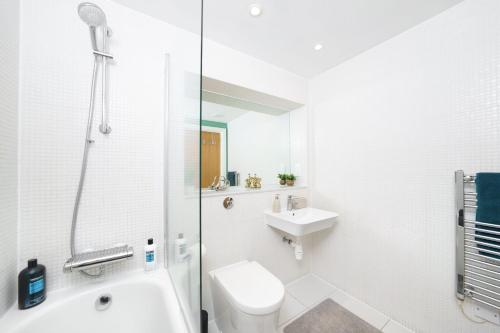 uma casa de banho com um chuveiro, um WC e um lavatório. em Cobalt Point 2 em Londres