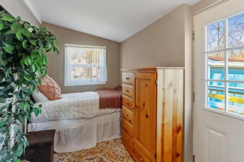 um quarto com uma cama, uma cómoda e uma janela em New charming Lakeview Haven 2BR Cozy Como Cottage with Lake Views em Lake Geneva