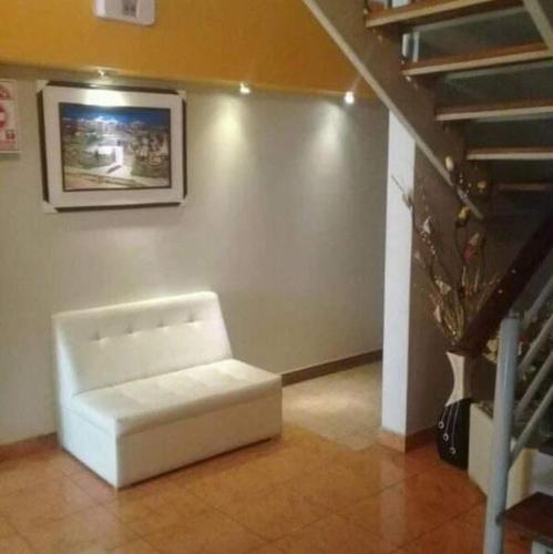 biała ławka siedząca w pokoju ze schodami w obiekcie Hostal Vanguts w mieście Huancayo