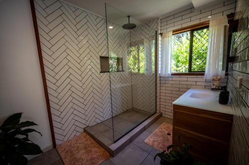 a bathroom with a shower and a sink at Tranquil Rainforest Studio Kuranda in Kuranda