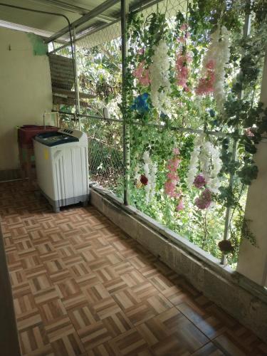 ein Zimmer mit einem Fenster mit Blumen draußen in der Unterkunft Departamento Yaqui in Aguas Claras