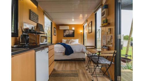 a tiny house bedroom with a bed and a kitchen at The Junction in Yarra Junction