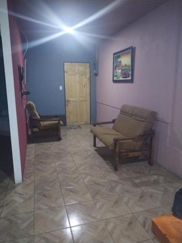 ein Wohnzimmer mit einem Sofa und 2 Stühlen in der Unterkunft Departamento Yaqui in Aguas Claras