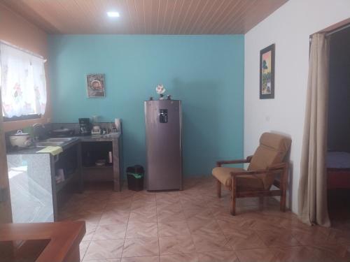 ein Wohnzimmer mit einem Kühlschrank und einem Stuhl in der Unterkunft Departamento Yaqui in Aguas Claras
