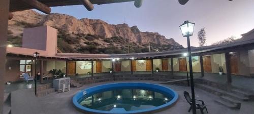 a house with a swimming pool in front of a mountain at Hosteria Puerta de Corral Quemado in Las Juntas