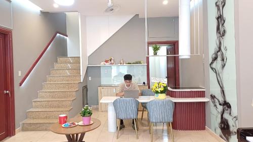 a person sitting at a table with a laptop at REDHOME DORM in Ho Chi Minh City