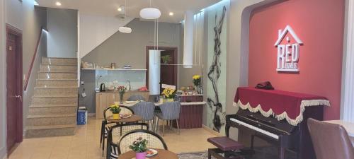 a living room with a piano and a kitchen at REDHOME DORM in Ho Chi Minh City