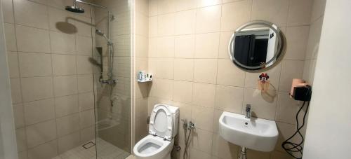 a bathroom with a toilet and a sink and a mirror at APPLE CloverLeafs Homestay Melaka in Melaka