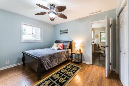 - une chambre avec un lit et un ventilateur de plafond dans l'établissement Lake Chemung Cottage Near Crystal Gardens, à Howell