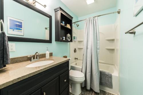 La salle de bains est pourvue d'un lavabo, de toilettes et d'une douche. dans l'établissement Lake Chemung Cottage Near Crystal Gardens, à Howell