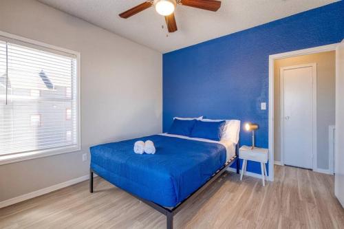 a blue bedroom with a bed with two white shoes on it at Cozy 2BD Apt Austin Texas in Austin