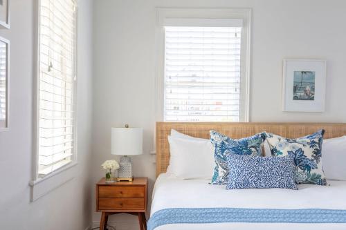 a bedroom with a bed with blue and white pillows at Cabana House at Casa Zoe in Charleston